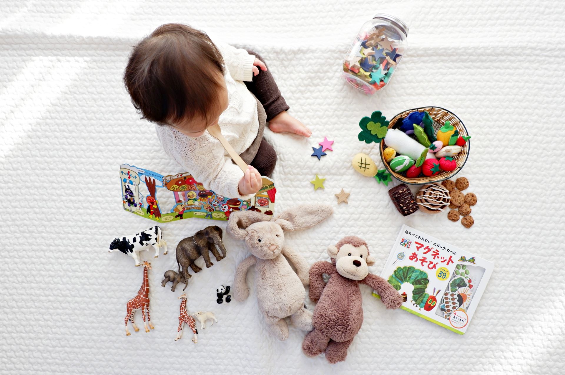 a baby with a  group of stuffed animals